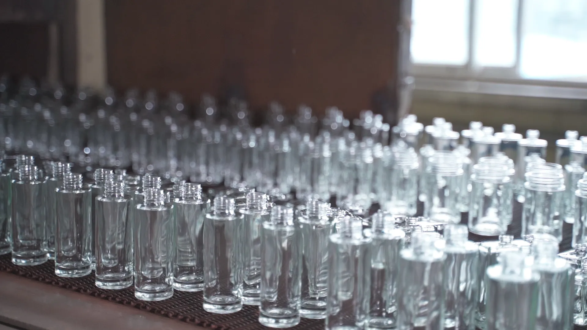 Newly formed clear glass containers moving through the controlled cooling stage
