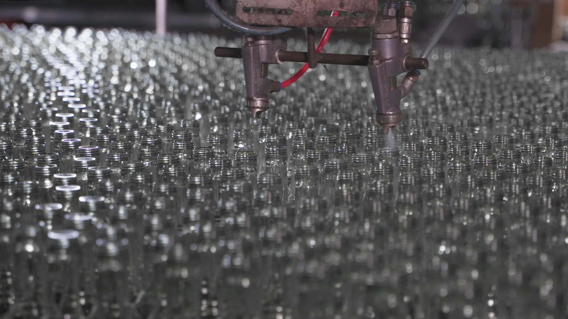 Protective coating being applied to clear glass containers on the production line